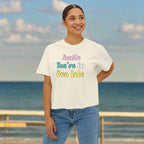 Woman wearing a white t-shirt with colorful text 'smile you're in Sea Isle' on a white background